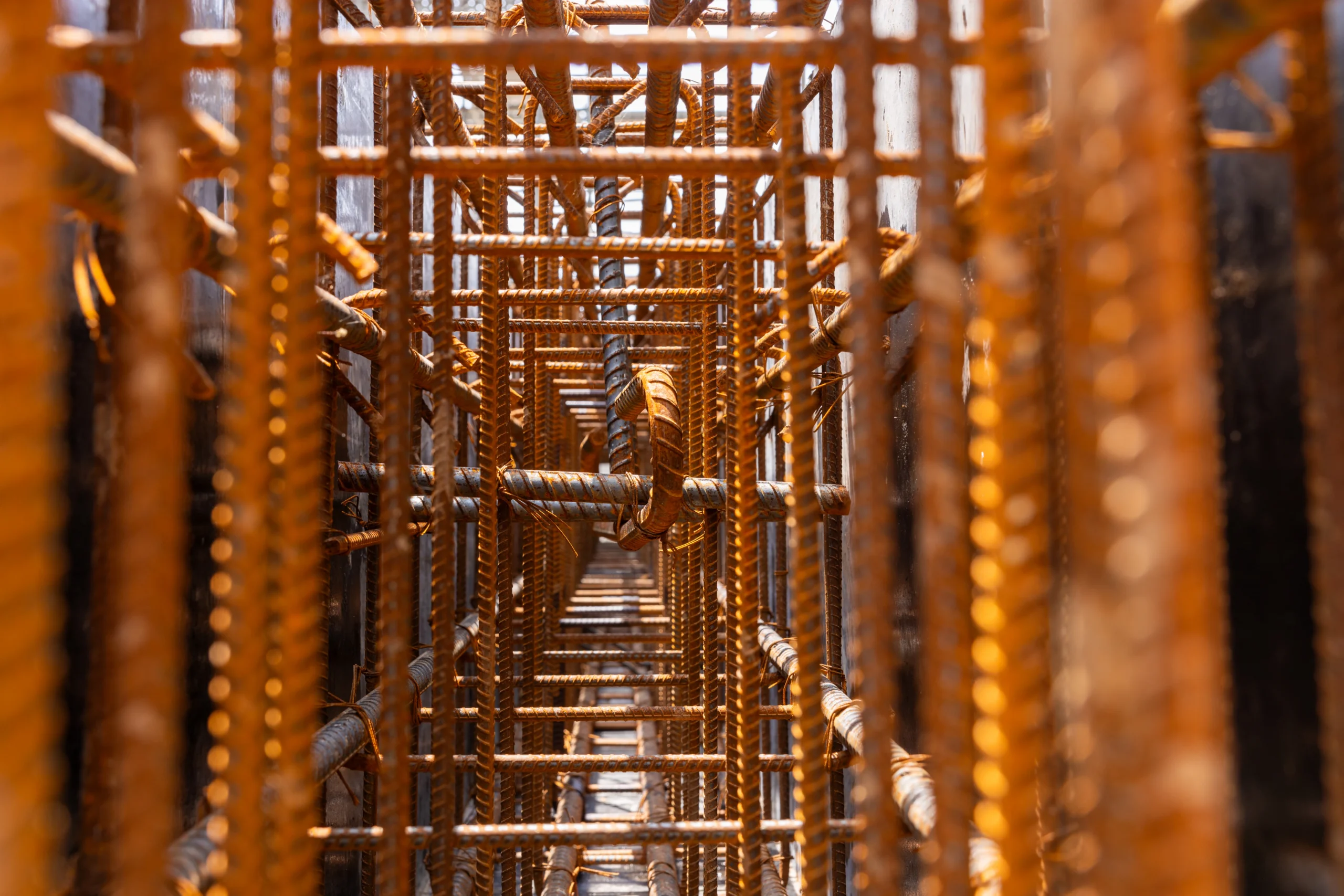 close-up-of-reinforced-steel-rebar-in-concrete-str-2026-03-19-23-34-43-utc Close-up view of intersecting steel reinforcement bars arranged in a grid pattern, used for concrete construction, photographed from within the structure.